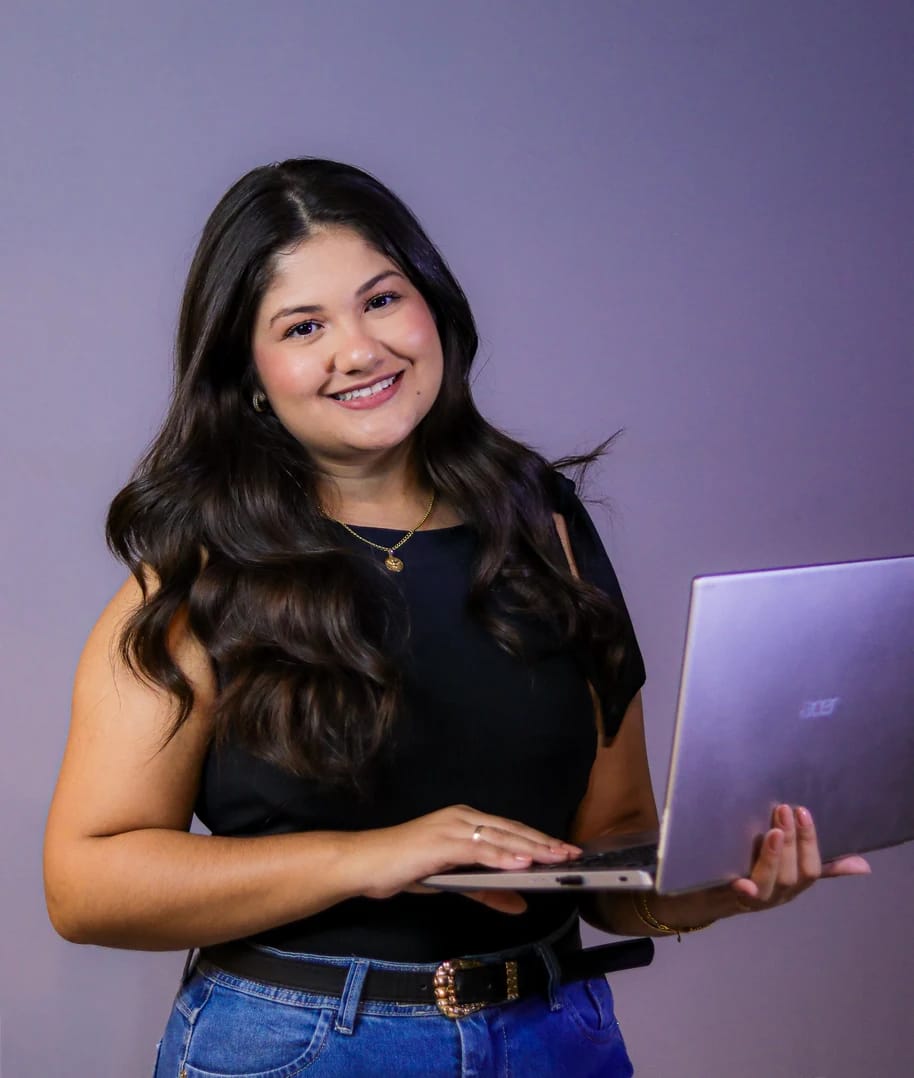 Mulher de camiseta preta sorrindo, segurando um notebook