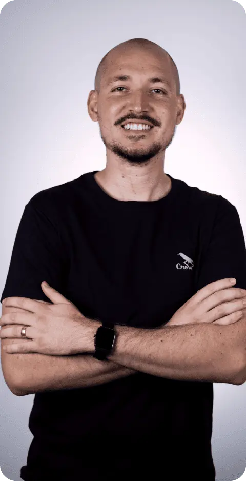foto de um homem sorrindo com os braços cruzados