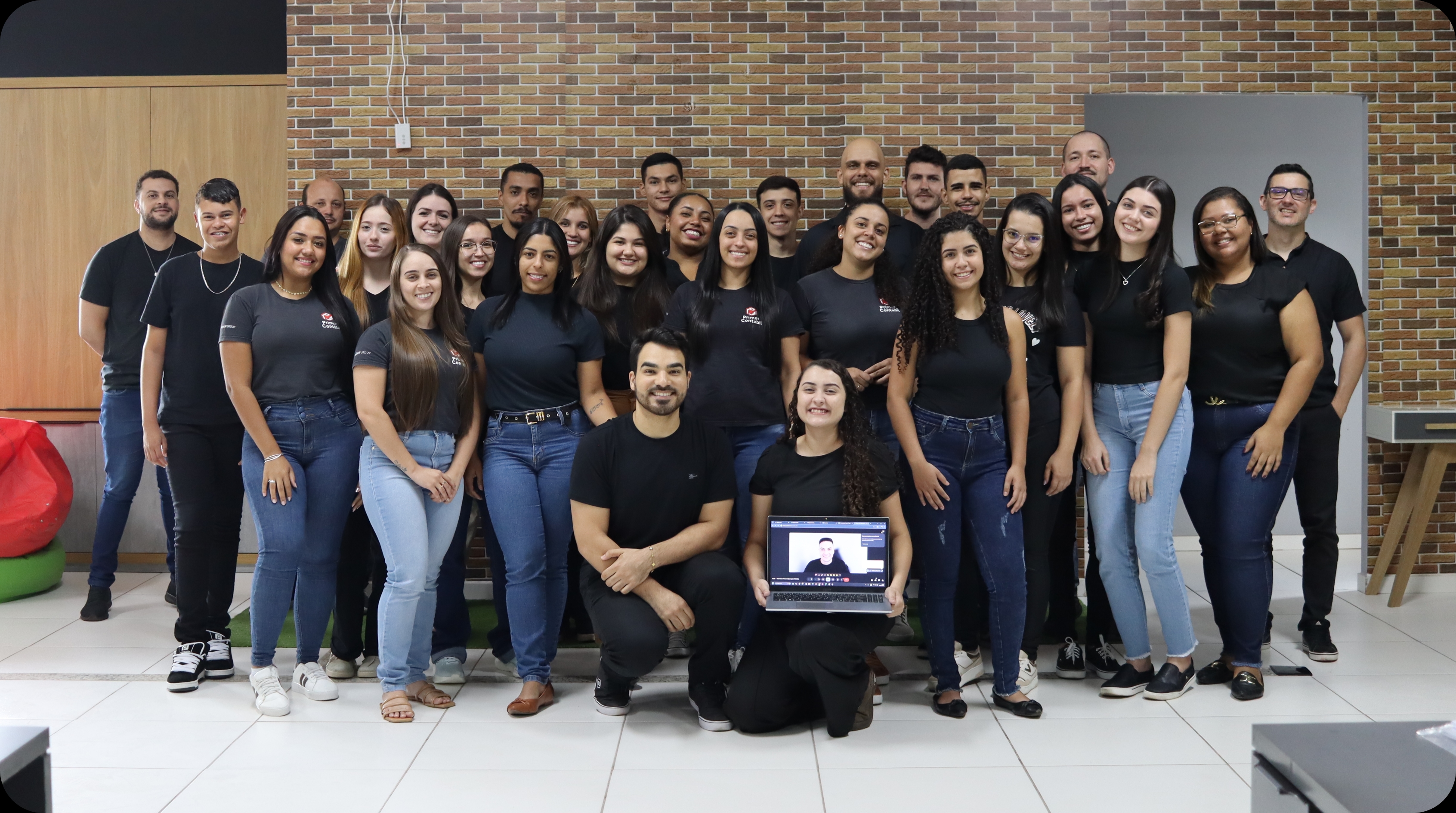 Imagem de um homem com camiseta vermelha olhando para a tela do computador
